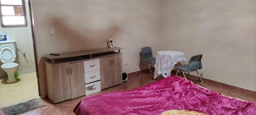 a room with a table and two chairs and a desk at Live with the locals in Bamboo House in Tanji