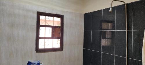 łazienka z oknem i prysznicem w obiekcie Live with the locals in Bamboo House w mieście Tanji