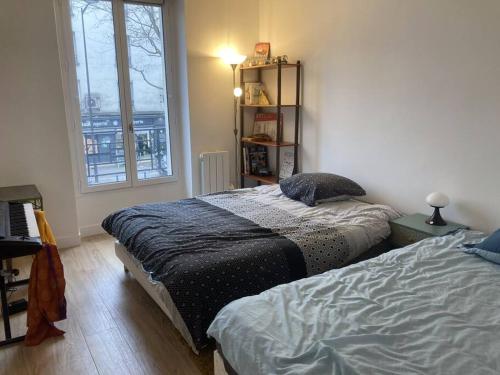 Ένα ή περισσότερα κρεβάτια σε δωμάτιο στο Superbe appartement proche Paris