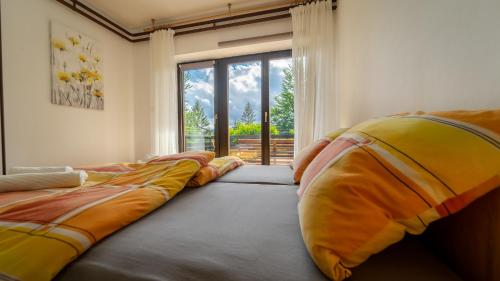 - 2 lits dans une chambre avec une grande fenêtre dans l'établissement Apartman Ornela, à Delnice
