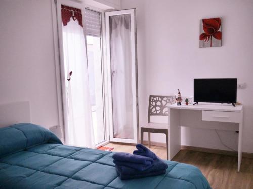 ein Schlafzimmer mit einem Bett und einem Schreibtisch mit einem Computer in der Unterkunft Da Nonna Maria in Grottaglie