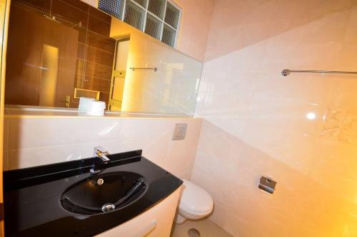 a bathroom with a black sink and a toilet at Family villa: pool and panoramic view in Praia