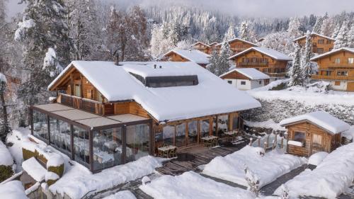 una casa cubierta de nieve en las montañas en Les Mazots du Clos en Villars-sur-Ollon