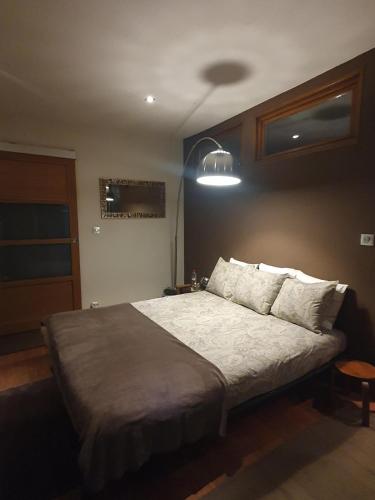 une chambre avec un lit et une lumière sur le mur dans l'établissement Chambre double accueillante avec douche privative, à Écully