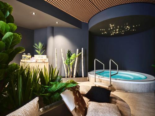 a bathroom with a hot tub and some plants at PLACES Obertauern by Valamar in Obertauern