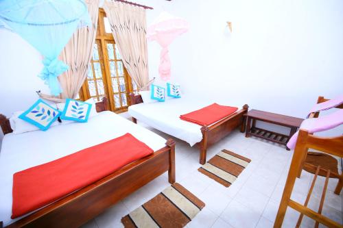 a room with two beds and a chair in it at Rose Villa Ella in Ella