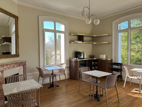 une salle à manger avec tables, chaises et fenêtres dans l'établissement Château de Moulède, à Linars