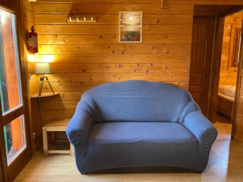 einen blauen Stuhl in einem Zimmer mit Holzwänden in der Unterkunft Camping-Chalets La Favière in Lac des Rouges Truites