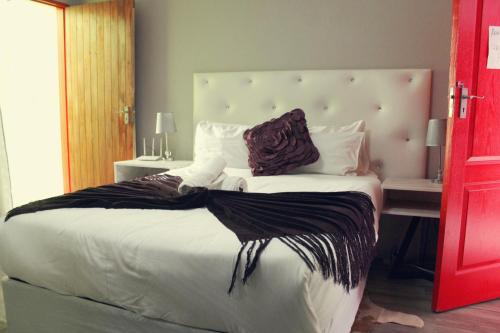una camera da letto con un letto grande con una grande testiera di El DiVino Guesthouse a Newcastle
