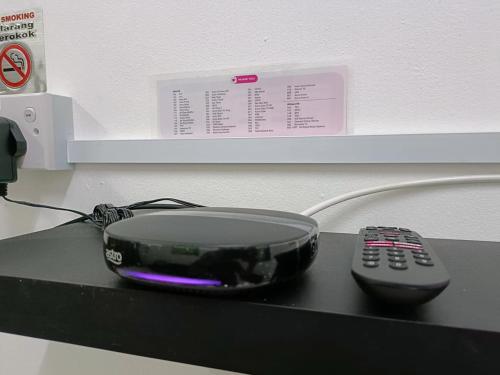 a remote control sitting on top of a black table at Adempuri Homestay 3 in Jitra