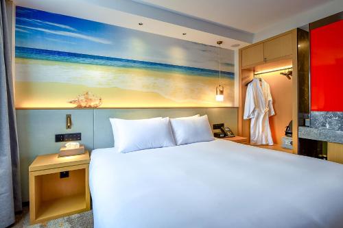 a bedroom with a bed and a painting of the beach at Aurea Hotel Perth Kings Park in Perth