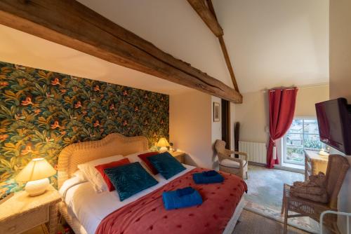 - une chambre avec un grand lit et une fresque murale dans l'établissement La Fontaine Cottage - Proximité historique - Bayeux, à Saint-Loup-Hors