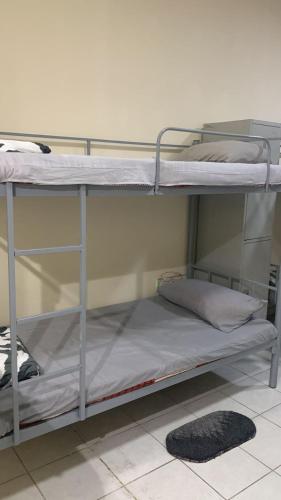 two bunk beds in a room with a rug at Boon Boys Bed Space Near Dubai Airport in Dubai