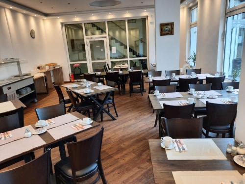 a restaurant with tables and chairs in a room at Hotel Residenz in Düsseldorf