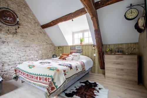 um quarto com uma cama e uma parede de pedra em Le Moulin de l'étang em Gilles