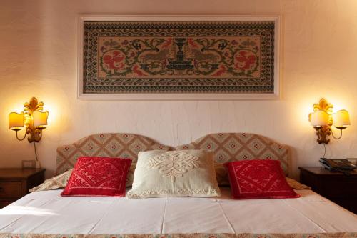 a bedroom with a bed with two red pillows at Nora Club Hotel & Spa in Pula