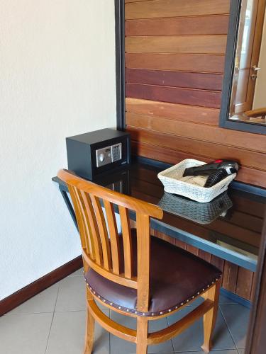 a wooden chair sitting at a desk with a telephone at The Guest Hotel & Hostel in Chiang Mai