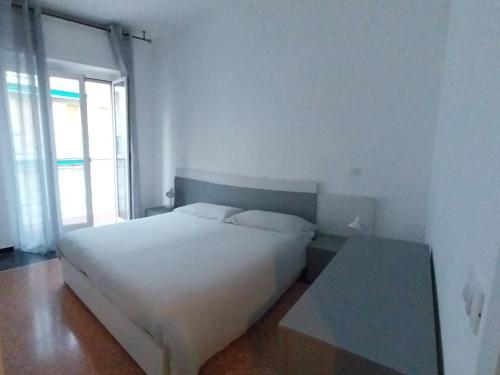 a bedroom with a white bed and a glass table at A casa di Anna in Finale Ligure