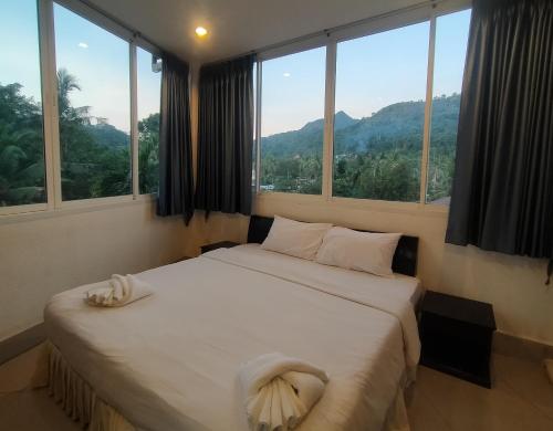 a bedroom with a bed with a view of a mountain at KOH CHANG LUXURY HOTEL in Ban Map Khangkhao