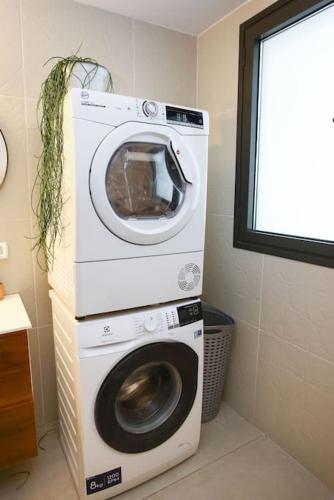 a washing machine and a dryer in a room at Ultra Luxury 3BR Beach Apartment in Tel Aviv