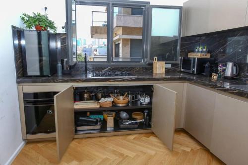 a kitchen with a counter with a sink and a counter at Ultra Luxury 3BR Beach Apartment in Tel Aviv