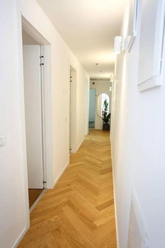 a hallway with white walls and a wooden floor at Ultra Luxury 3BR Beach Apartment in Tel Aviv