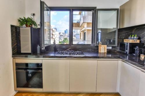 a kitchen with a counter top with a window at Ultra Luxury 3BR Beach Apartment in Tel Aviv