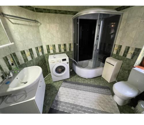 a bathroom with a sink and a toilet and a shower at Квартира на земле in Chişinău