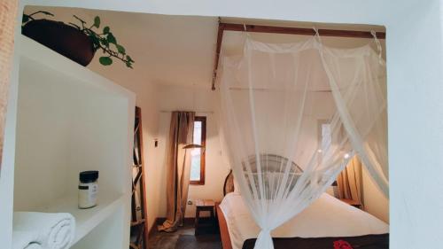 1 dormitorio con 1 cama con mosquitera en Hakha Beach House en Praia do Tofo