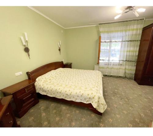 a bedroom with a bed and a dresser and a window at Квартира на земле in Chişinău