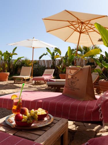a table with a plate of food on a table with an umbrella at Nora Club Hotel & Spa in Pula