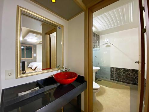 a bathroom with a red sink and a mirror at F1 Hotel in Mokpo