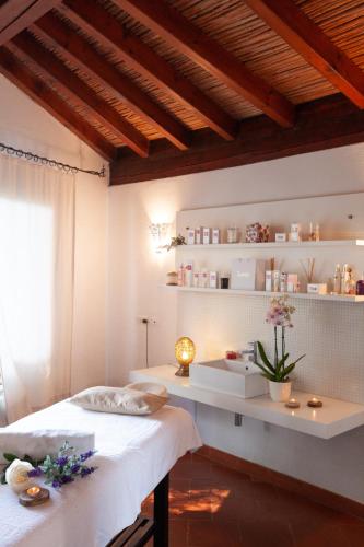 a bedroom with a bed and a desk with flowers at Nora Club Hotel & Spa in Pula