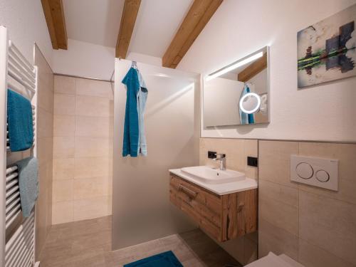 uma casa de banho com um lavatório e um espelho em Appartement Torblick em Ellmau