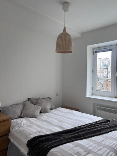 Dormitorio blanco con cama y ventana en Central , bright and modern flat up to 4 people en Londres