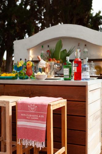a bar with a table and chairs with food on it at Nora Club Hotel & Spa in Pula