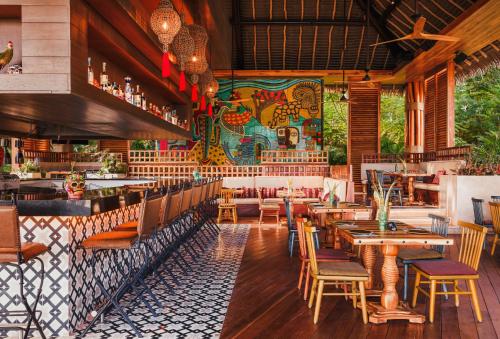 a restaurant with wooden tables and chairs and a mural at BON Hotel at VidantaWorld Nuevo Vallarta in Nuevo Vallarta