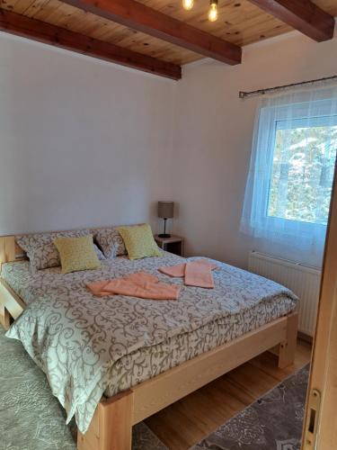 um quarto com uma cama num quarto com uma janela em Mokrogorska kuca em Mokra Gora
