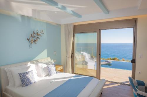 a bedroom with a bed and a view of the ocean at Olive and Aloe Villas in Nomikianá