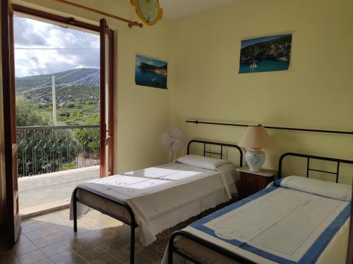 two beds in a room with a balcony at Casa Degli Oleandri Sul Cortile R6314 in Cala Gonone