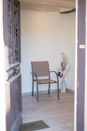 a chair sitting in the hallway of a house at Gîte La Tour des Remparts Pool & Jacuzzi in Saverne