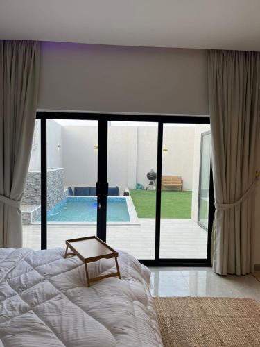 ein Schlafzimmer mit einem Bett und Blick auf einen Pool in der Unterkunft شاليهات بالما in Al Hofuf