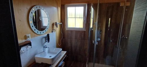 a bathroom with a sink and a shower with a mirror at PENZION PARMA in Ostružná