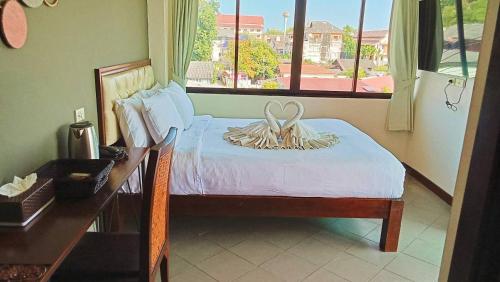 a bedroom with a bed and a desk and a window at The Guest Hotel & Hostel in Chiang Mai