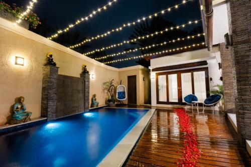 a swimming pool in a house with lights on the ceiling at Focus on 4 in Seminyak
