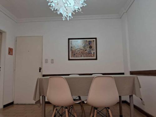 une salle à manger avec une table, des chaises et un lustre dans l'établissement RIO lodge, à San Nicolás de los Arroyos