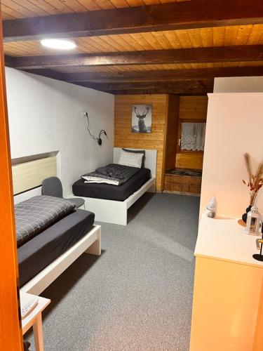 2 łóżka w pokoju z drewnianym sufitem w obiekcie AFA1 w mieście Göschenen