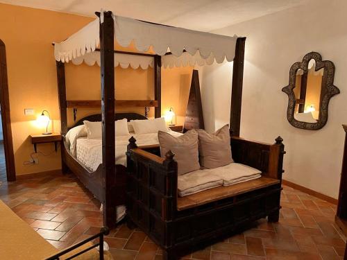 a bedroom with a four poster bed and a mirror at Ca' Datu in Finale Ligure