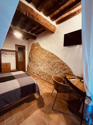a bedroom with a bed and a desk and a television at La Casina BFF in Magliano in Toscana