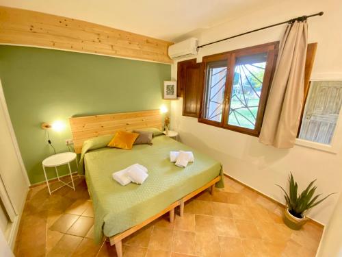 a bedroom with a green bed and a window at Residence La Rosa in Porto San Paolo